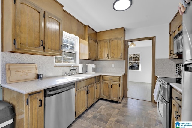 kitchen featuring tasteful backsplash, appliances with stainless steel finishes, and sink