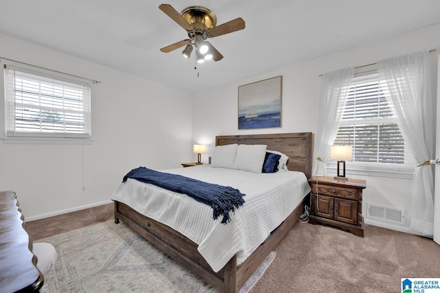 carpeted bedroom with multiple windows and ceiling fan