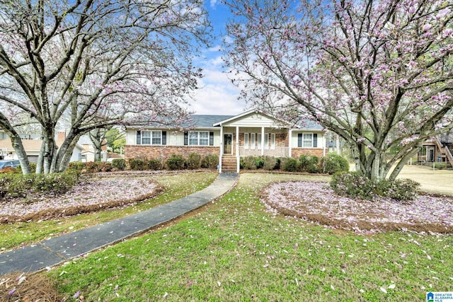 single story home featuring a front lawn and covered porch