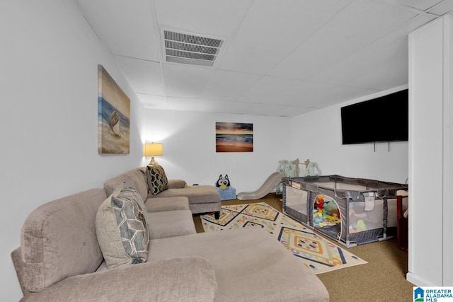 living room featuring a drop ceiling and carpet floors