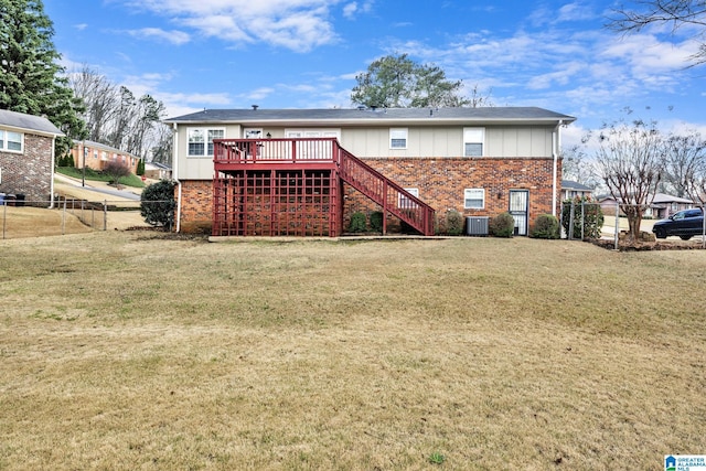 rear view of house with cooling unit, a deck, and a lawn