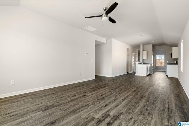 unfurnished living room featuring vaulted ceiling, dark hardwood / wood-style floors, and ceiling fan