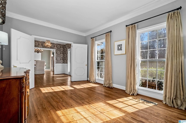 interior space featuring ornamental molding, plenty of natural light, and hardwood / wood-style floors