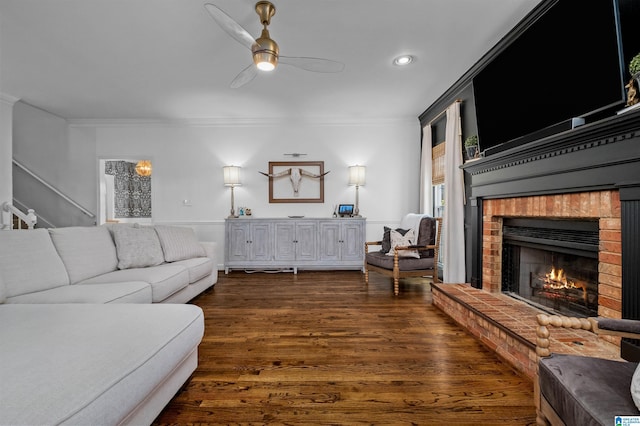 living room featuring crown molding, a brick fireplace, ceiling fan, and dark hardwood / wood-style flooring