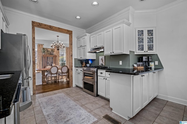 kitchen with white cabinetry, ornamental molding, a chandelier, and range with two ovens