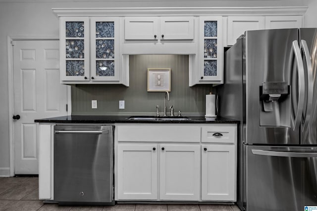 kitchen featuring white cabinetry, appliances with stainless steel finishes, sink, and dark stone counters