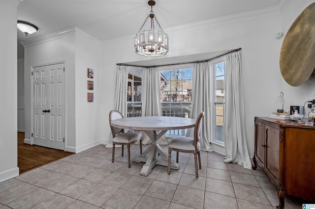 tiled dining space featuring crown molding and an inviting chandelier