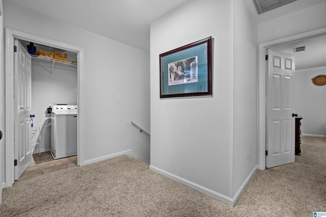 corridor with washer / dryer and light colored carpet