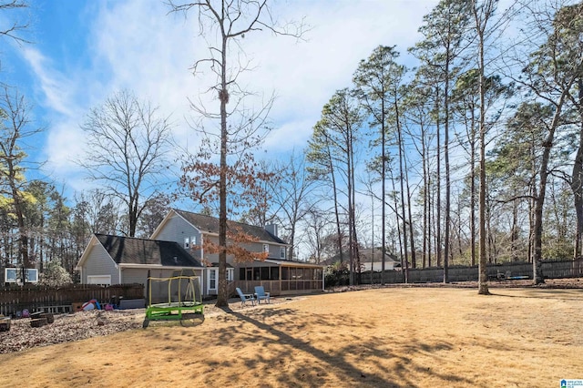 view of yard with a sunroom and a trampoline