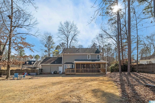 rear view of property featuring a yard and a sunroom