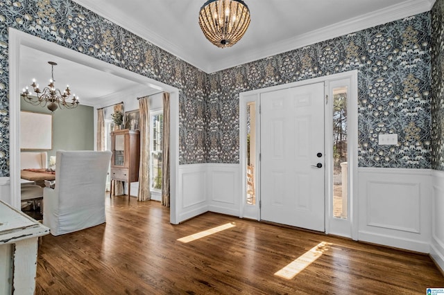 entrance foyer featuring ornamental molding, hardwood / wood-style floors, and a chandelier