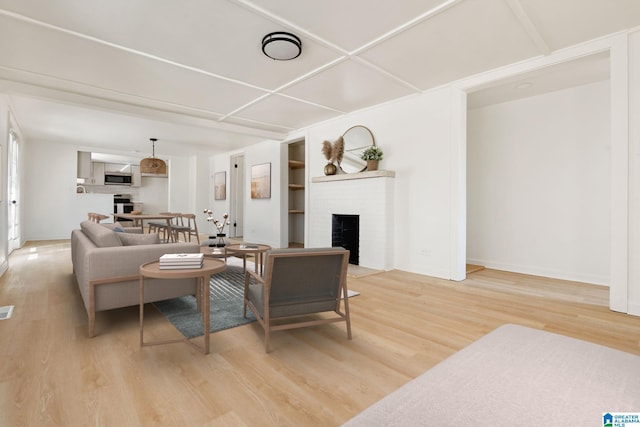 living room featuring a brick fireplace and hardwood / wood-style flooring