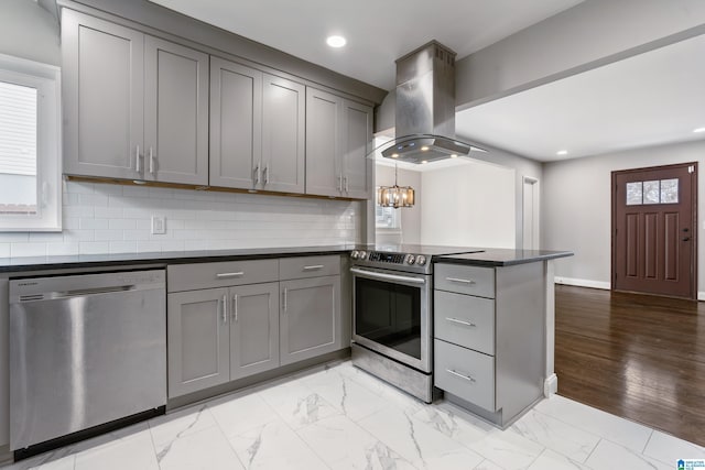 kitchen with gray cabinetry, appliances with stainless steel finishes, kitchen peninsula, and island range hood