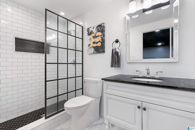 bathroom with vanity, tiled shower, and toilet