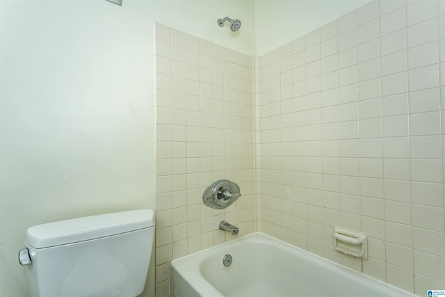 bathroom featuring tiled shower / bath and toilet