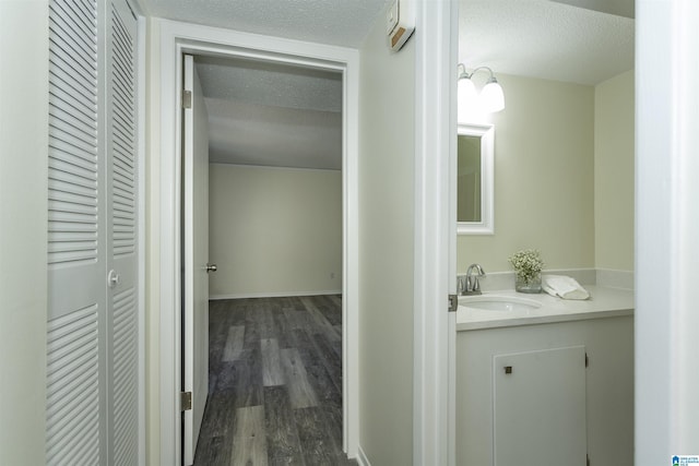 bathroom with vanity, wood-type flooring, and a textured ceiling