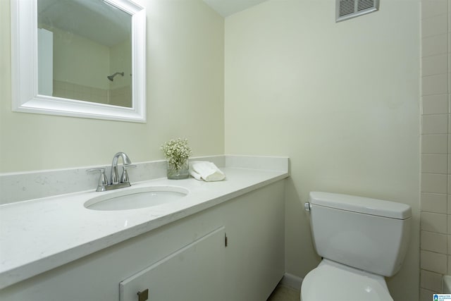 bathroom featuring vanity, a shower, and toilet