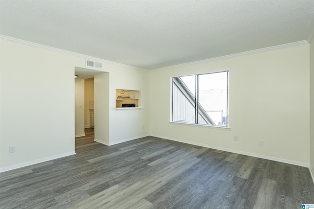 spare room featuring dark wood-type flooring, ornamental molding, and a textured ceiling