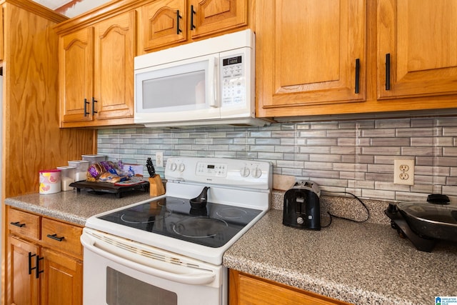 kitchen featuring tasteful backsplash and white appliances