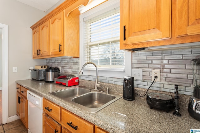 kitchen featuring tasteful backsplash, sink, tile patterned floors, and dishwasher