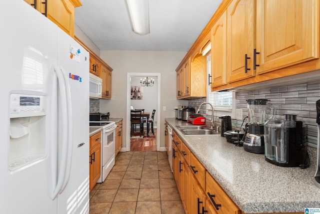 kitchen with sink, a chandelier, light tile patterned floors, white appliances, and decorative backsplash