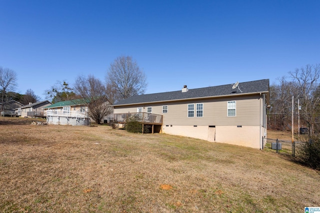 back of property featuring a pool side deck and a yard