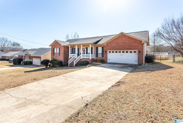 ranch-style home featuring a garage, a porch, and a front lawn