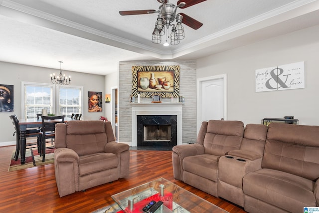 living room with dark hardwood / wood-style floors, ceiling fan with notable chandelier, a tray ceiling, a premium fireplace, and a textured ceiling