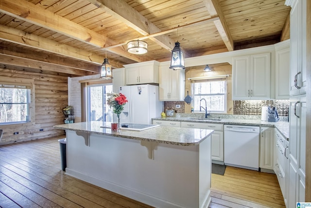 kitchen featuring hanging light fixtures, white cabinetry, a center island, and white appliances