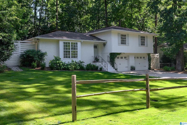 tri-level home with a garage and a front yard