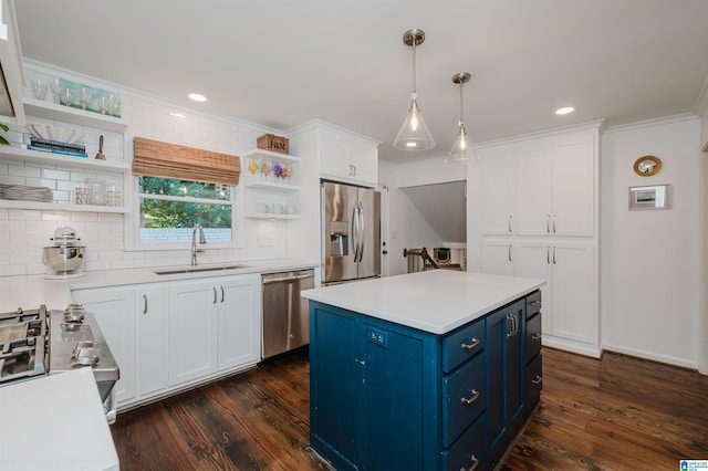 kitchen with sink, appliances with stainless steel finishes, white cabinetry, blue cabinets, and decorative light fixtures