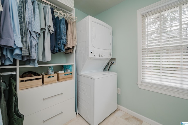 clothes washing area with stacked washing maching and dryer