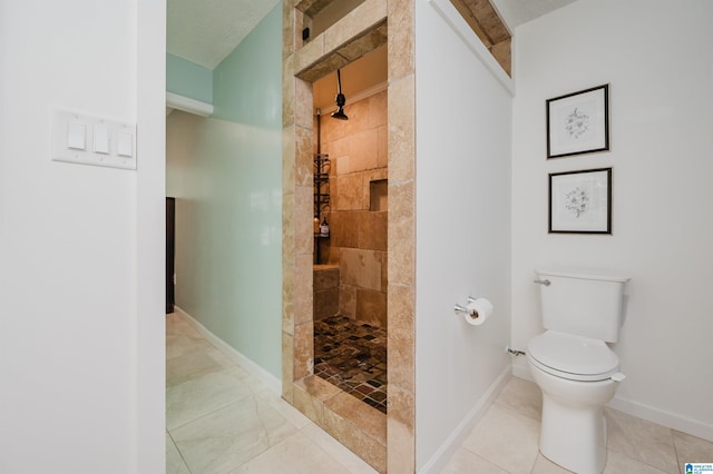 bathroom featuring a tile shower, tile patterned floors, and toilet