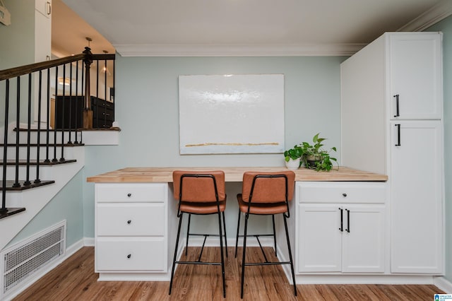 kitchen with wood counters, light hardwood / wood-style flooring, and white cabinets