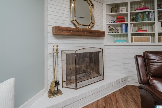 room details featuring wood-type flooring and a brick fireplace