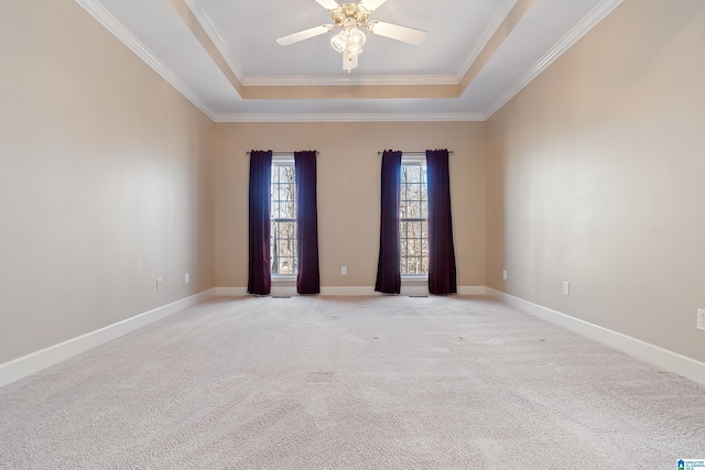 spare room with light carpet, ornamental molding, a raised ceiling, and ceiling fan