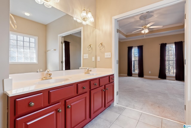 bathroom with tile patterned floors, ornamental molding, a tray ceiling, vanity, and ceiling fan