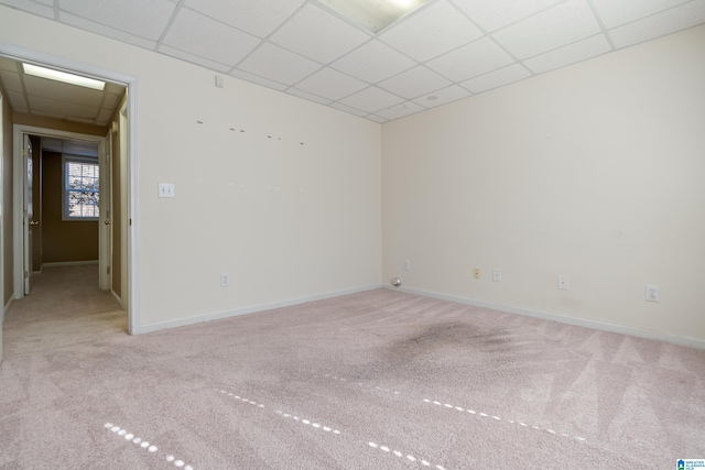 carpeted empty room featuring a paneled ceiling