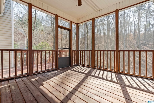 unfurnished sunroom featuring ceiling fan and a healthy amount of sunlight