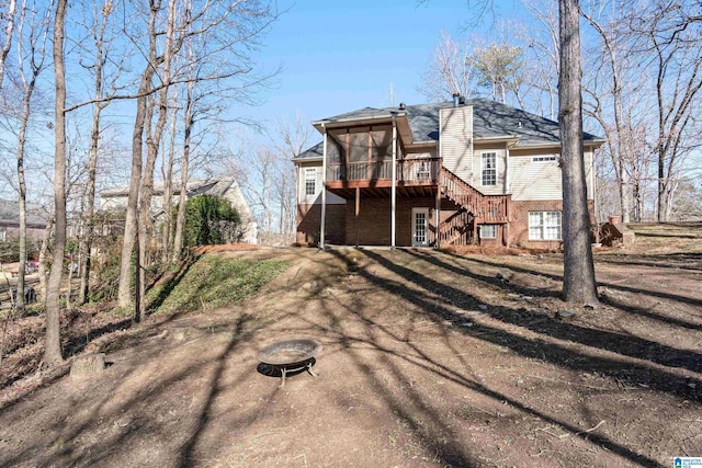 rear view of property featuring a wooden deck and a sunroom