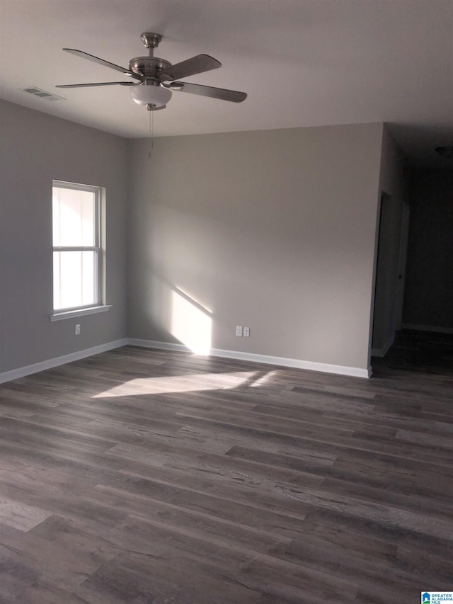 empty room with dark wood-type flooring and ceiling fan