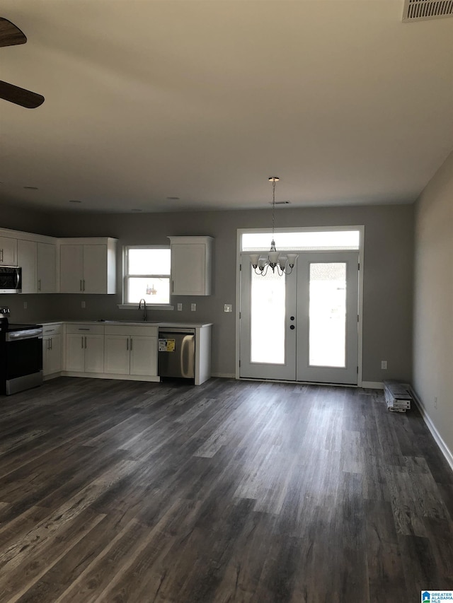 kitchen featuring white cabinetry, hanging light fixtures, stainless steel appliances, and dark hardwood / wood-style floors