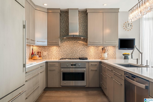 kitchen featuring stainless steel appliances, sink, wall chimney range hood, and gray cabinets