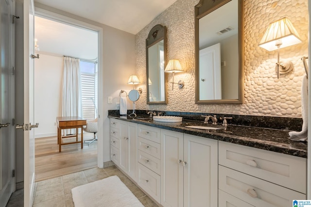 bathroom with tasteful backsplash, vanity, and tile patterned flooring