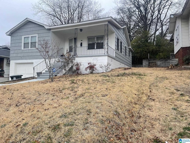 view of front of home with a garage, a front lawn, and covered porch