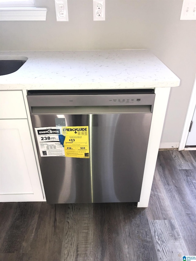 interior details with white cabinetry, dark hardwood / wood-style floors, sink, and dishwashing machine