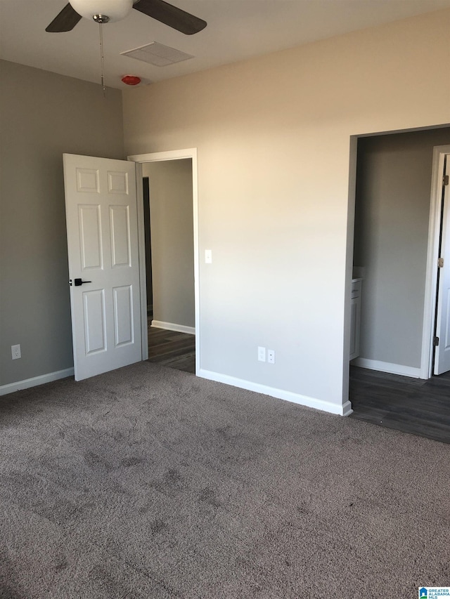 unfurnished bedroom with ceiling fan and dark colored carpet