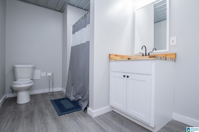 bathroom featuring wood-type flooring, vanity, and toilet