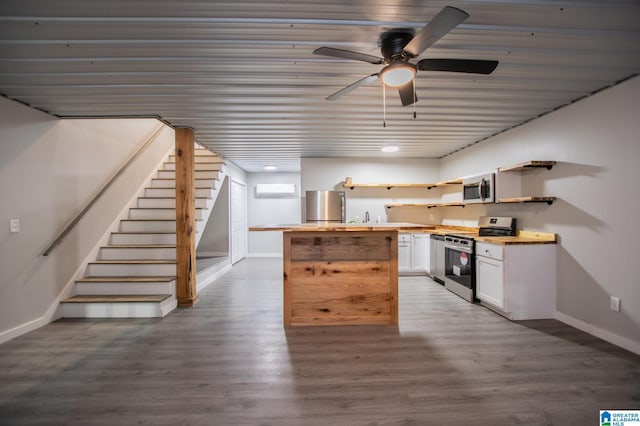 kitchen featuring appliances with stainless steel finishes, an AC wall unit, white cabinetry, sink, and dark hardwood / wood-style flooring