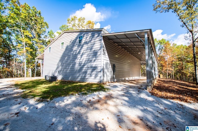 view of property exterior with a carport and central AC unit